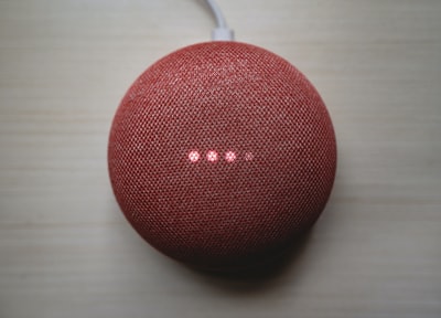 棕色木桌上的红色圆形便携式扬声器